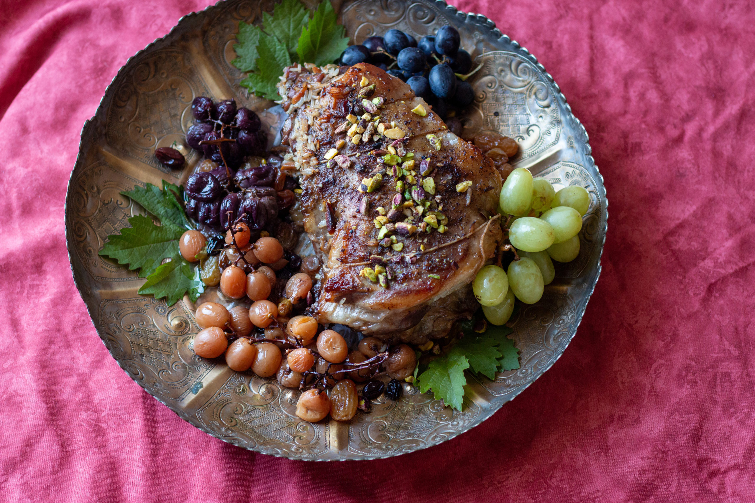 Lamb’s neck stuffed with raisins and grapes on a brass plate