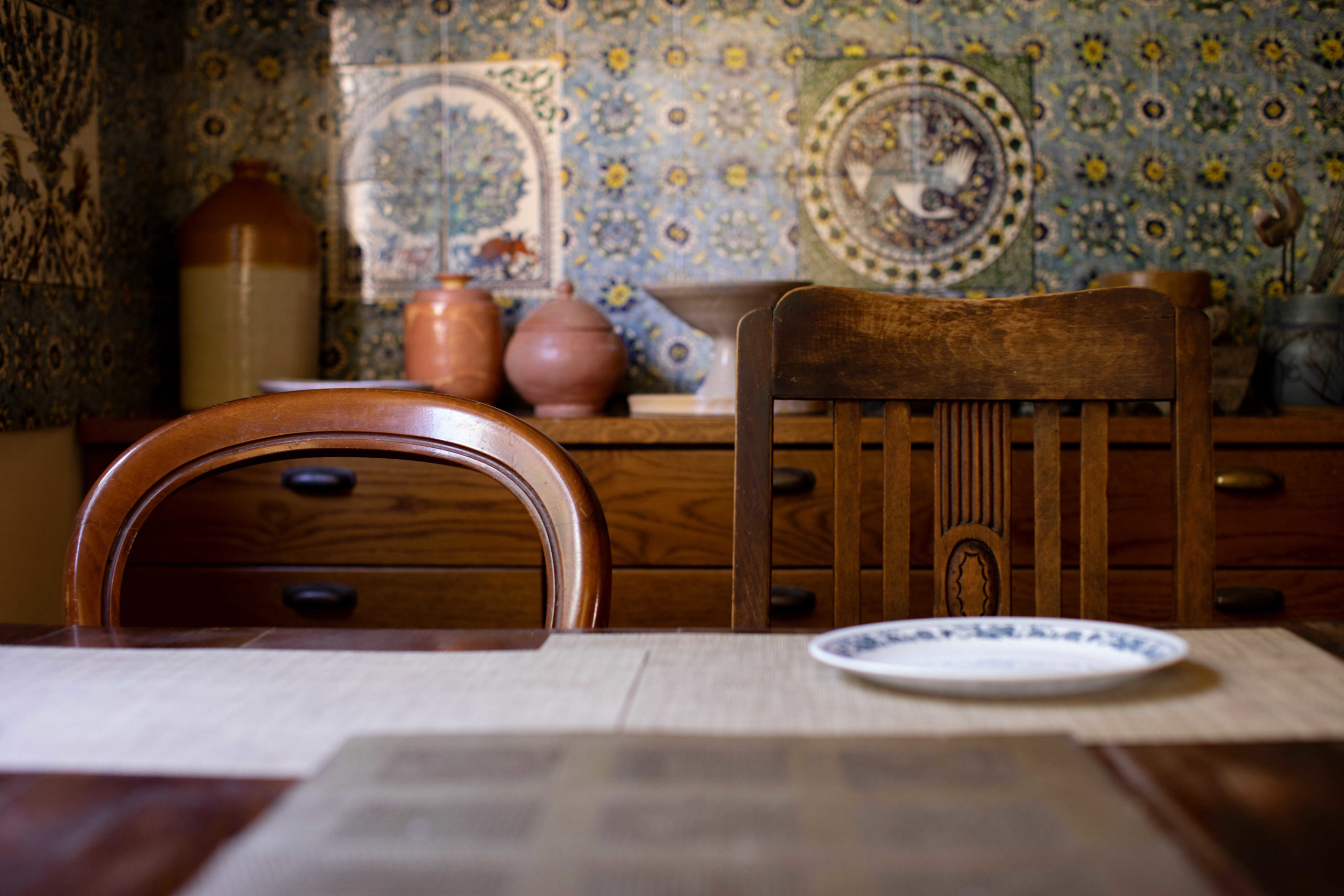 Nechama Rivlin's kitchen table with two chairs and blue and white tiles in the background