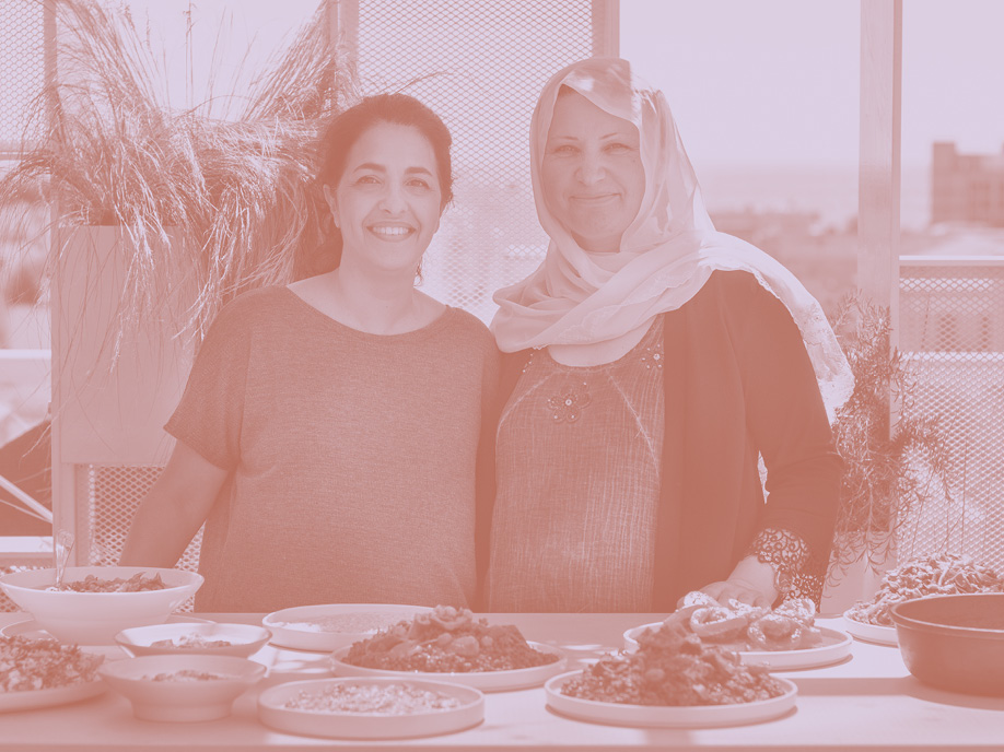 Syrian cooks Safaa Ibrahim and SIgi Mantel together in a kitchen