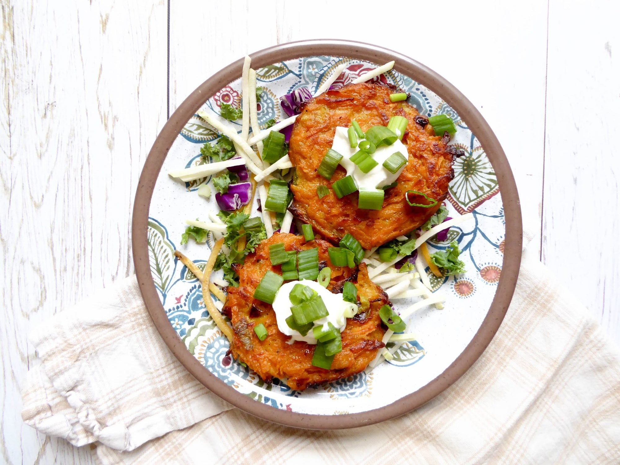 oven baked sweet potato latkes topped with scallions and sour cream