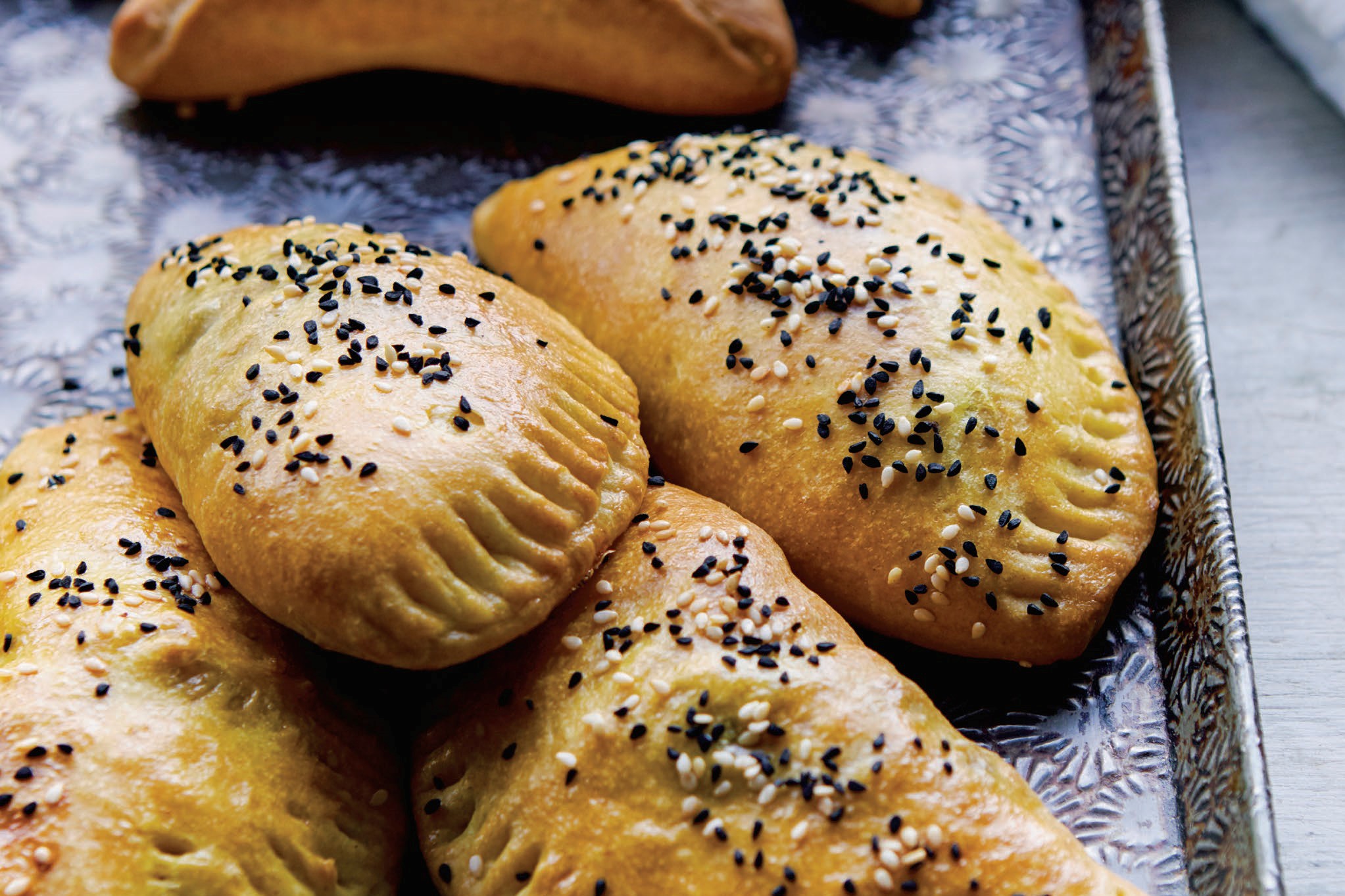Sambousek, savory pastries topped with nigella and sesame seeds