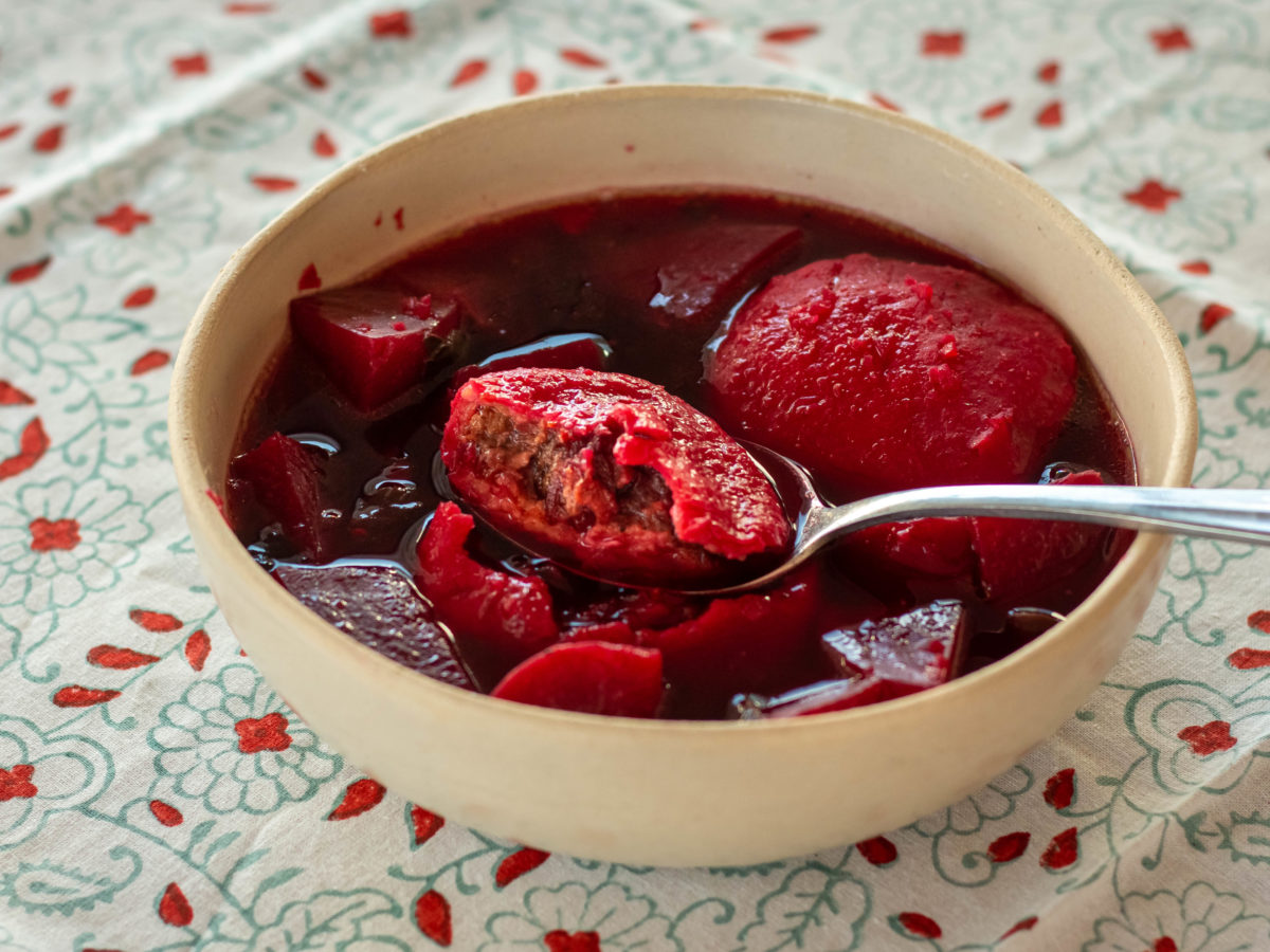 Beet kubbeh soup in a white bowl