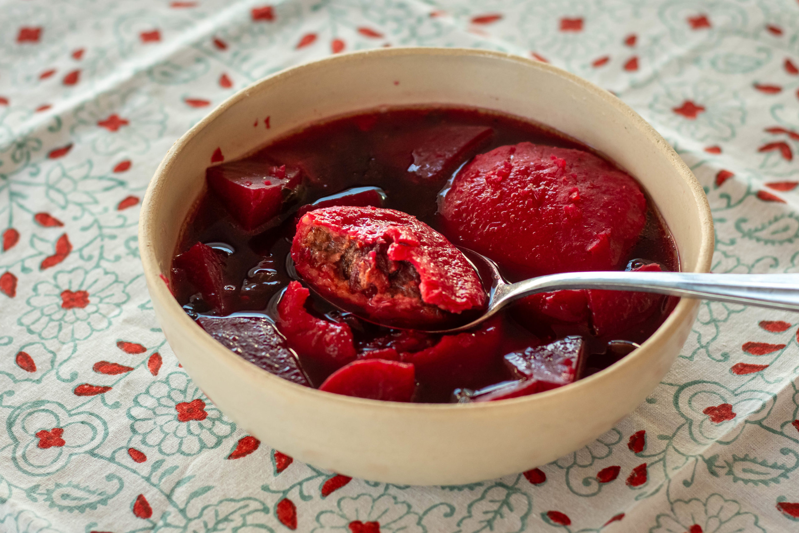 Beet kubbeh soup in a white bowl