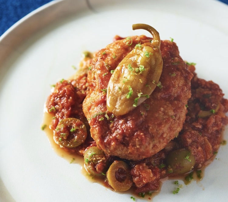 Fish patty in tomato sauce with pepper on top