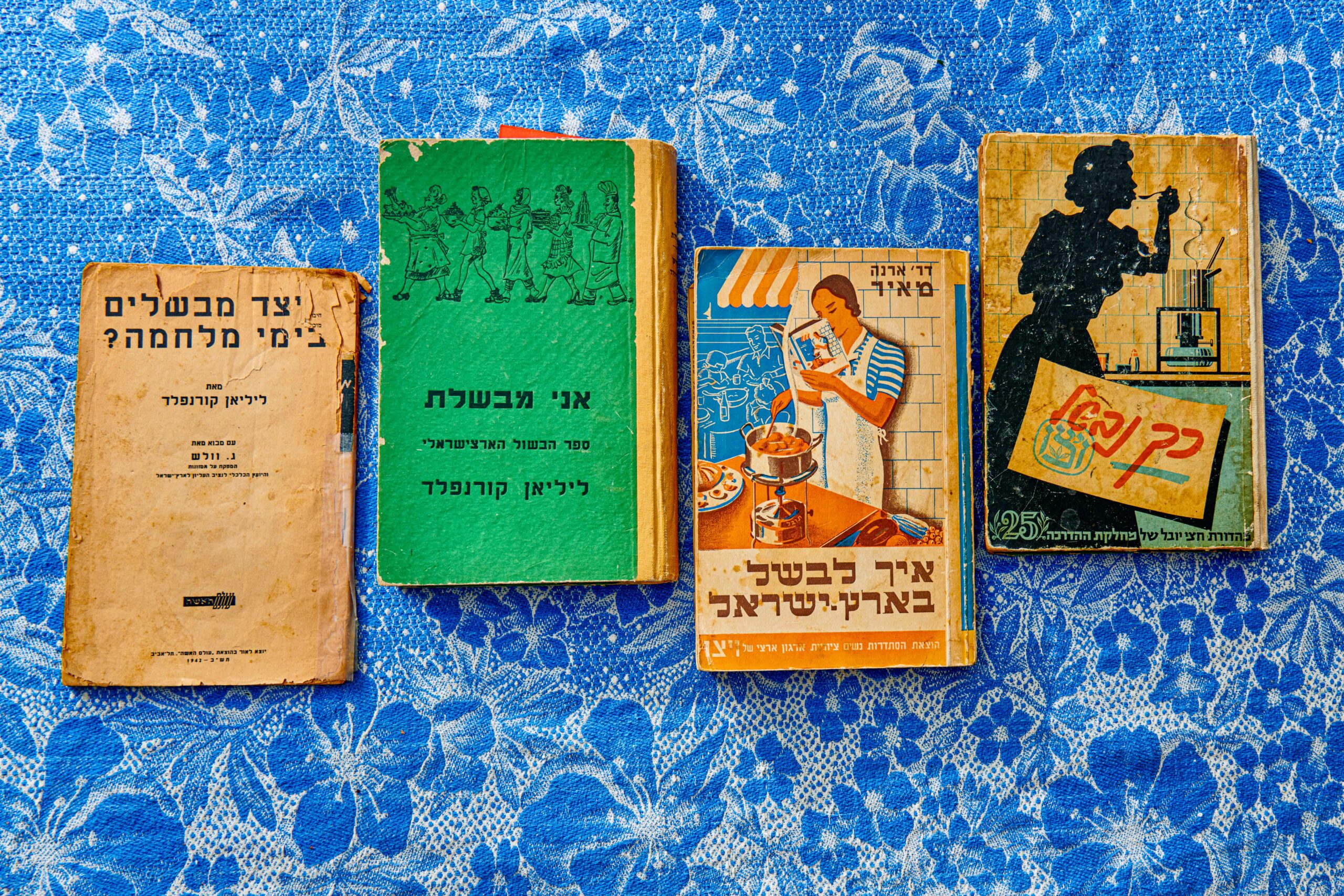 Vintage Hebrew cookbooks on blue floral tablecloth