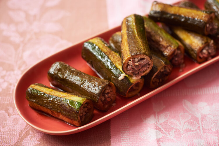 Zucchini stuffed with meat and rice on red oval plate