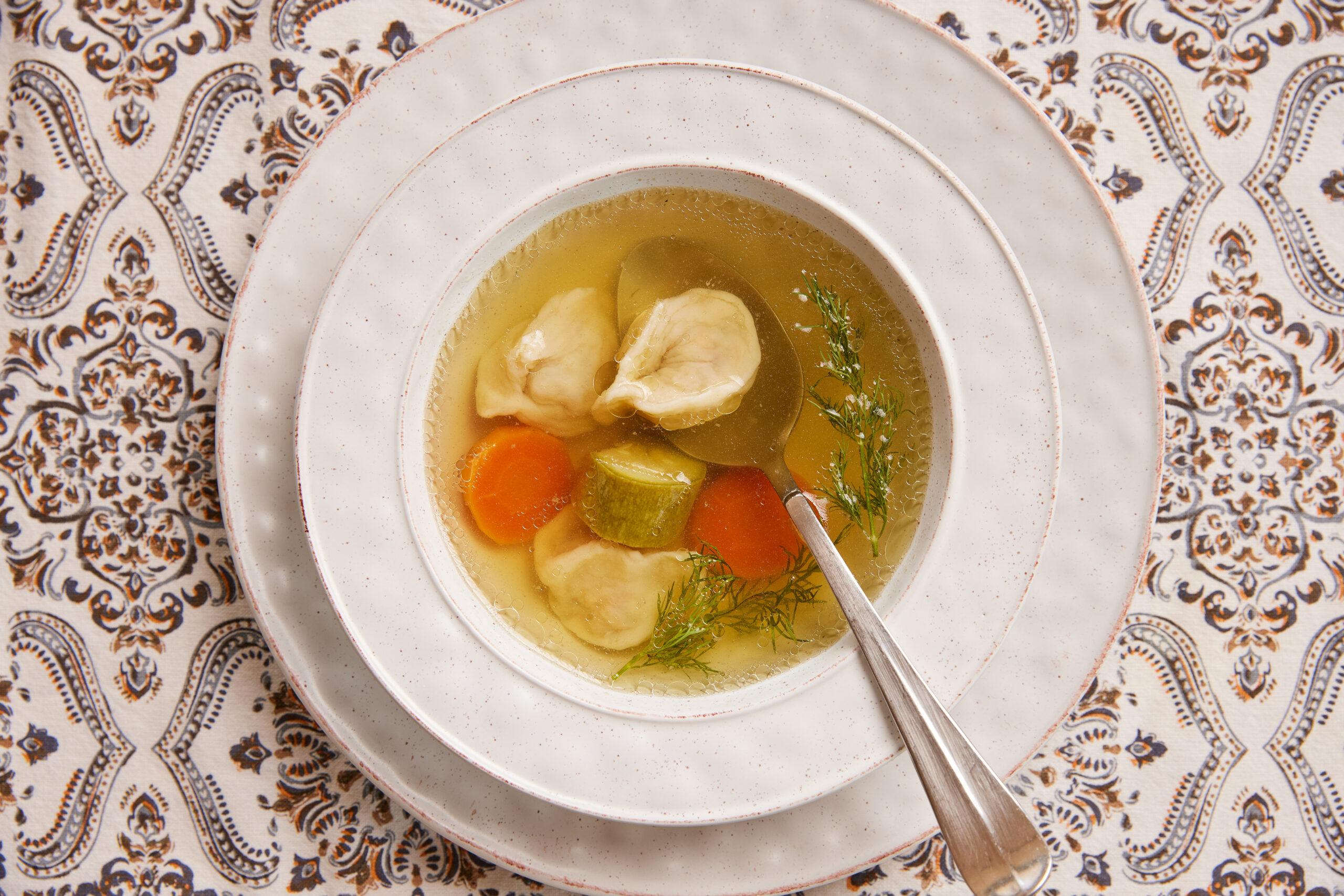 Kreplach (Jewish dumplings) soup with clear broth, carrots and zucchini