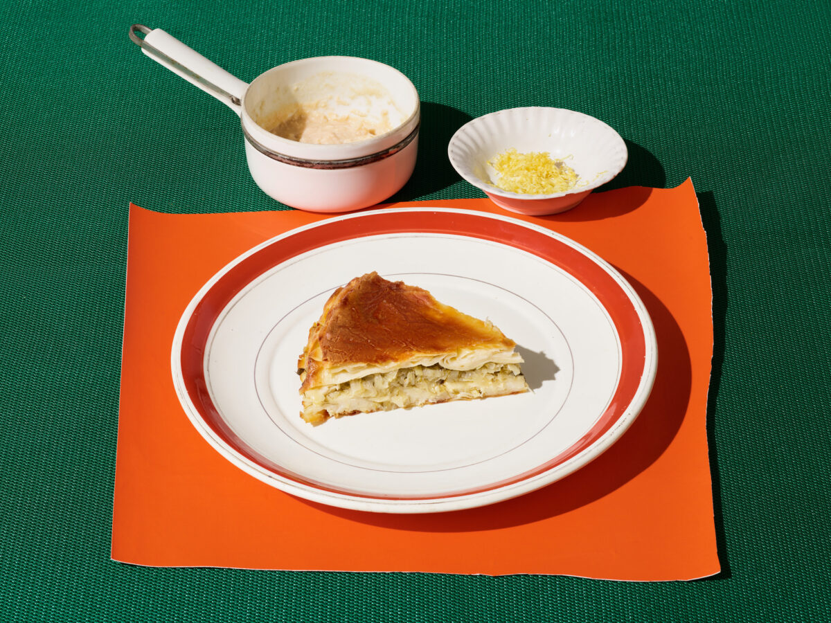 Slice of water borek with crab filling on white and orange plate