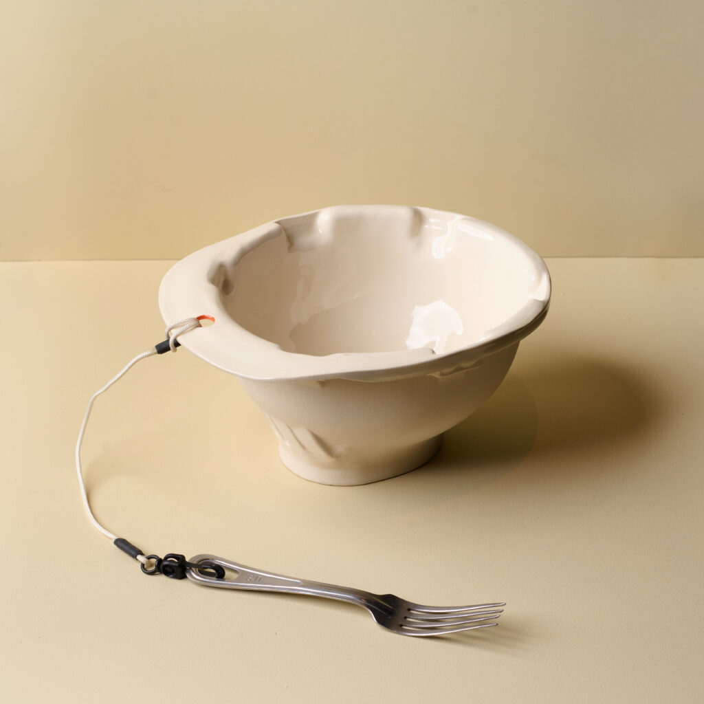 White ceramic bowl with fork attached with cord
