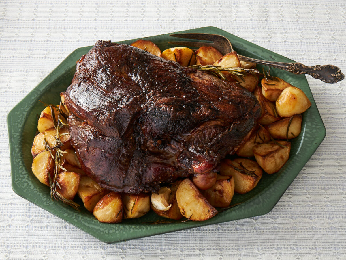 Lamb shoulder with potatoes on green plate