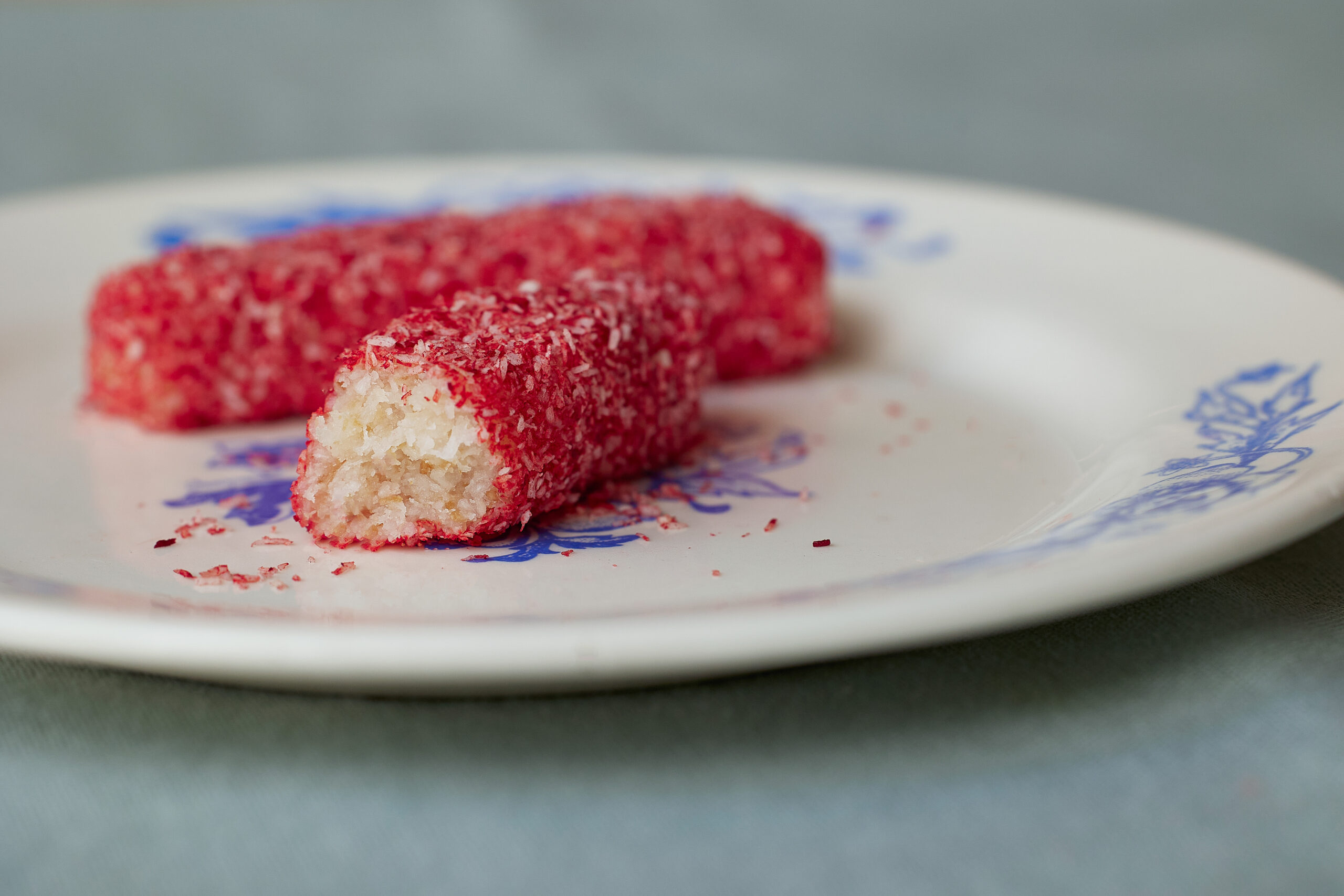 Pink coconut candies on a white and blue plate