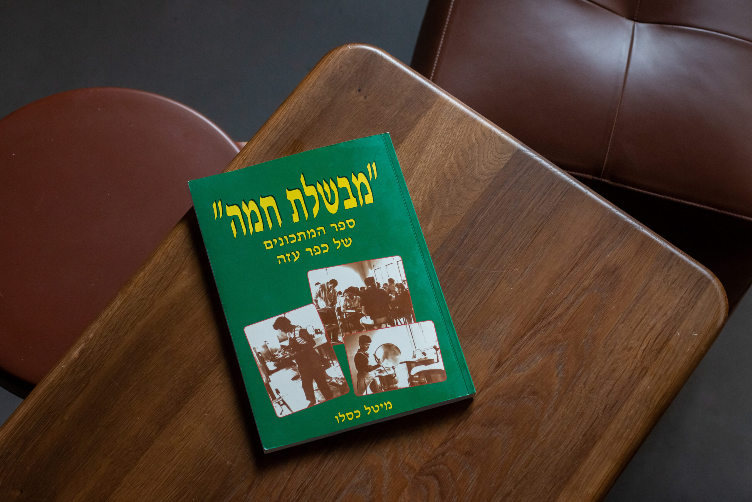 A community cookbook from Kibbutz Kfar Aza on a wooden table