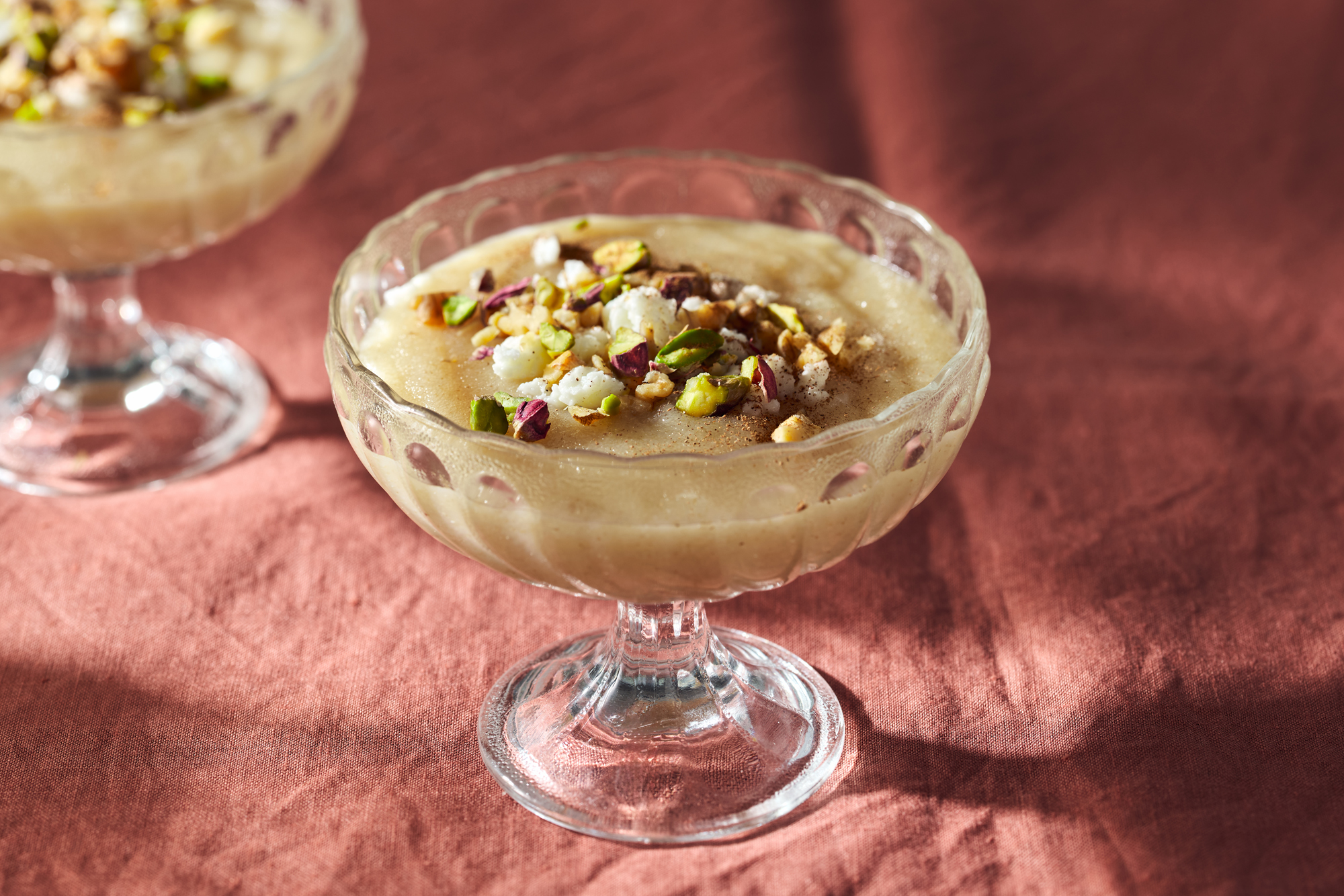 Mamounia (Syrian Semolina Pudding) with pistachios  on a pink tablecloth